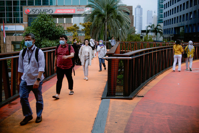 Suasana pekerja yang berkantor di kawasan Sudirman saat jam pulang kerja melintas di kawasan JPO Phinisi, Jakarta, Selasa (29/11/2022). Foto: Jamal Ramadhan/kumparan