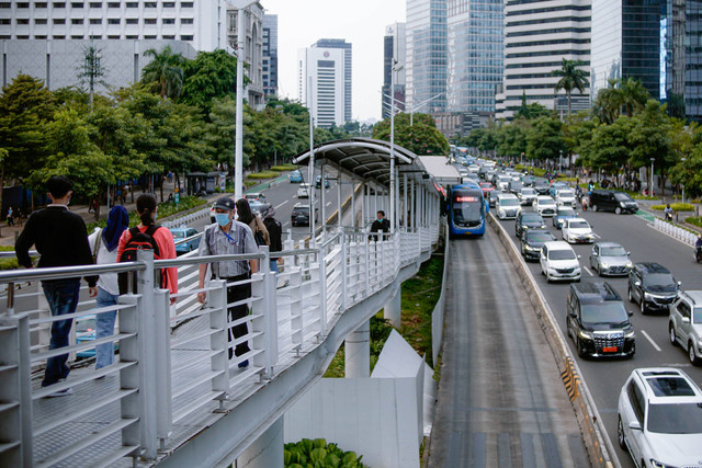 Suasana pekerja yang berkantor di kawasan Sudirman saat jam pulang kerja melintas di kawasan JPO Phinisi, Jakarta. Foto: Jamal Ramadhan/kumparan