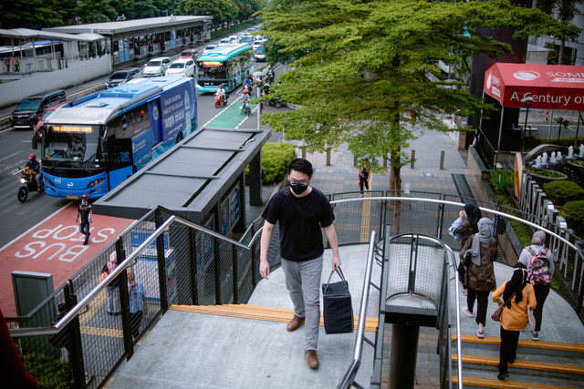 Suasana pekerja yang berkantor di kawasan Sudirman saat jam pulang kerja melintas di kawasan JPO Phinisi, Jakarta, Selasa (29/11/2022). Foto: Jamal Ramadhan/kumparan