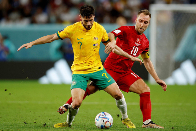 Pemain Timnas Denmark Christian Eriksen berebut bola dengan pemain Timnas Australia Mathew Leckie pada pertandingan Grup D Piala Dunia 2022 Qatar di Stadion Al Janoub, Al Wakrah, Qatar. Foto: John Sibley/REUTERS