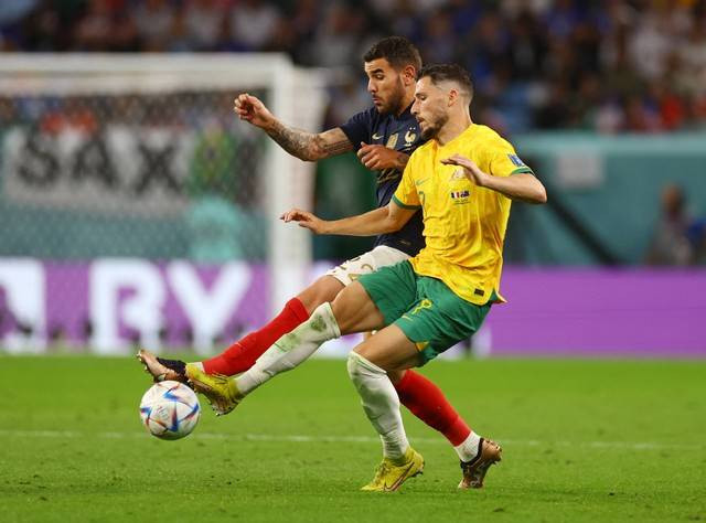 Theo Hernandez dari Prancis duel dengan Mathew Leckie dari Australia pada pertandingan Piala Dunia Qatar 2022 Grup D di Stadion Al Janoub, Al Wakrah, Qatar. Foto: Kai Pfaffenbach/Reuters