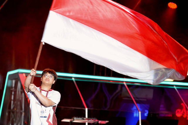 Atlet esport Indonesia Rizqi Awandi Iskandar mengibarkan bendera saat defile atlet dalam pembukaan International Esports Federation (IESF) Bali 14th World Esports Championship 2022 di Nusa Dua, Badung, Bali, Jumat (2/12/2022). Foto: Fikri Yusuf/ANTARA FOTO