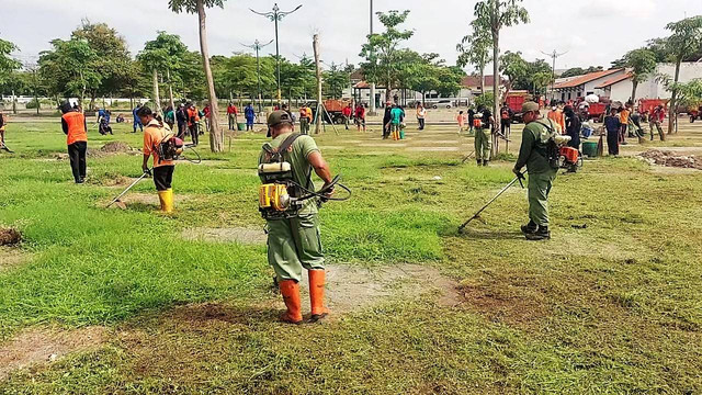 Peserta kerja bakti memotong rumput di Pamedan Pura Mangkunegaran, Solo, Sabtu (03/12/2022). FOTO: Fernando Fitusia