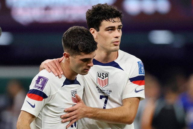 Pemain Amerika Serikat Christian Pulisic dan Giovanni Reyna terlihat sedih setelah pertandingan karena Amerika Serikat tersingkir dari Piala Dunia di Stadion Internasional Khalifa, Doha, Qatar, Sabtu (3/12/2022). Foto: Wolfgang Rattay/REUTERS