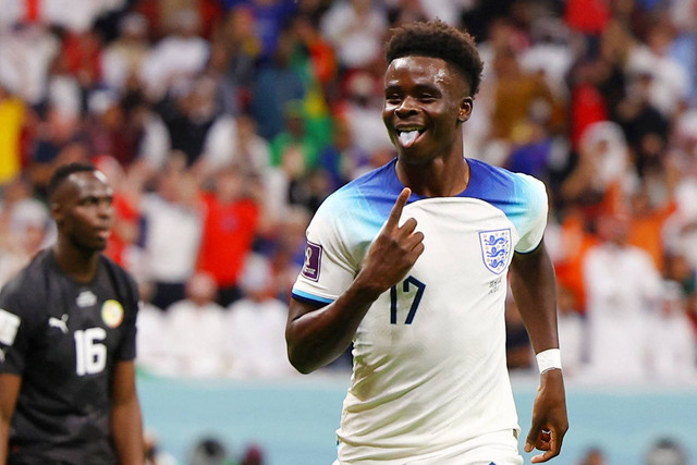 Pemain Inggris Bukayo Saka merayakan gol ketiganya saat lawan Senegal pada babak 16 besar Piala Dunia 2022, di Stadion Al Bayt, Al Khor, Qatar, Minggu (4/12/2022). Foto: Kai Pfaffenbach/REUTERS
