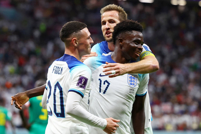 Pemain Inggris Bukayo Saka merayakan gol ketiga mereka dengan Harry Kane dan Phil Foden saat lawan Senegal pada babak 16 besar Piala Dunia 2022, di Stadion Al Bayt, Al Khor, Qatar, Minggu (4/12/2022). Foto: Kai Pfaffenbach/REUTERS