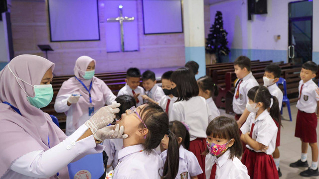 Murid SD Methodist Banda Aceh mengikuti imunisasi polio yang dilaksanakan petugas Puskesmas Kuta Alam di sekolah setempat, Senin (5/12/2022). Foto: Suparta/acehkini