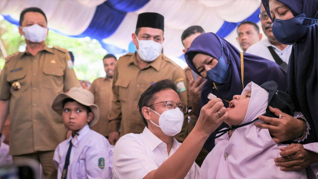 Menkes Budi Gunadi meneteskan vaksin polio kepada anak-anak di Anjong Mon Mata, Banda Aceh, Senin (5/12/2022). Foto: Abdul Hadi/acehkini  