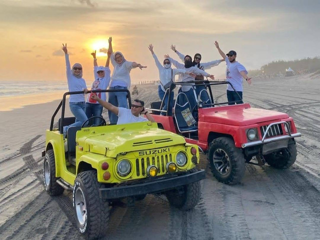 Wisatawan berfoto di kawasan Pantai Parangtritis menggunakan mobil jip. Foto: Dok. Putra Fajar