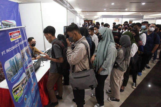 Sejumlah pencari kerja mencari informasi lowongan kerja saat Bursa Kerja ASSiK (Arek Suroboyo Siap Kerjo) di Convention Hall Jalan Arief Rahman Hakim, Surabaya, Jawa Timur, Selasa (6/12/2022). Foto: Didik Suhartono/Antara Foto