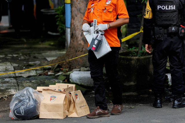 Petugas INAFIS Polda Jabar mengumpulkan barang bukti saat olah TKP bom bunuh diri di kawasan Astana Anyar, Bandung, Jawa Barat, usai ledakan bom bunuh diri, Rabu (7/12/2022). Foto: Willy Kurniawan/REUTERS