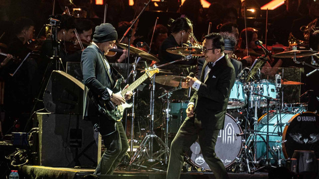 Gitaris Dewa 19 Andra Ramadhan (kiri) tampil bersama vokalis Ari Lasso (kanan) dalam konser bertajuk Dewa 19 - A Night At The Orchestra Episode 2 di Jakarta International Velodrome, Jakarta, Sabtu (10/12/2022). Foto: Aprillio Akbar/ANTARA FOTO