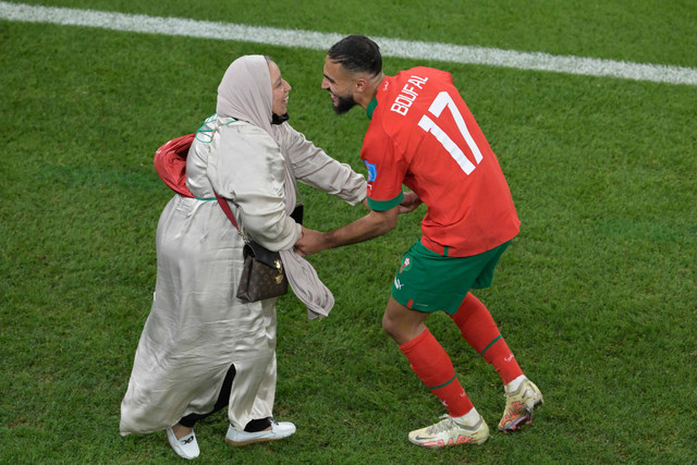 Gelandang Maroko, Sofiane Boufal merayakan bersama ibunya setelah lolos ke babak semi final setelah mengalahkan Portugal 1-0 dalam pertandingan sepak bola perempat final Piala Dunia Qatar 2022, di Stadion Al-Thumama, Doha, Qatar, Sabtu (10/12/2022). Foto: JUAN MABROMATA/AFP