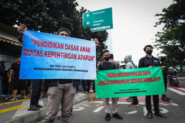 Sejumlah relawan membentangkan spanduk saat rencana pengosongan aset di SDN Pondok Cina 1, Depok, Jawa Barat, Minggu (11/12/2022). Foto: Asprilla Dwi Adha/ANTARA FOTO