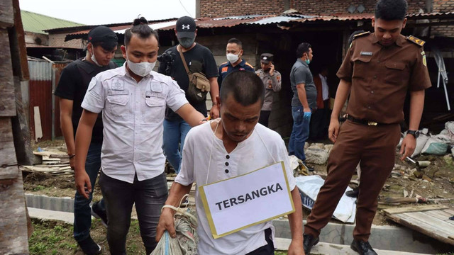 Polisi saat merekontruksi kasus suami mutilasi dan bakar istri di Kabupaten Humbang Hasudutan (Humbahas), Sumatera Utara. Foto: Polres Humbahas