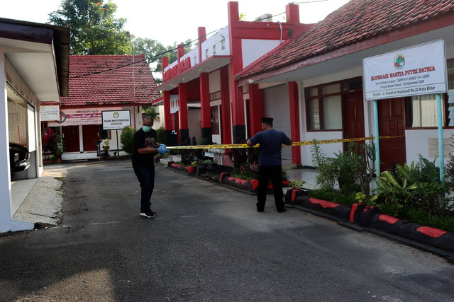 Petugas memasang garis polisi saat olah TKP di salah satu ruangan Rumah Dinas (Rumdin) Wali Kota Blitar, Jawa Timur, Senin (12/12/2022). Foto: Irfan Anshori/Antara Foto