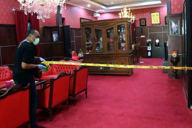 Petugas memasang garis polisi saat olah TKP di salah satu ruangan Rumah Dinas (Rumdin) Wali Kota Blitar, Jawa Timur, Senin (12/12/2022). Foto: Irfan Anshori/Antara Foto