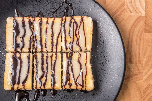 Roti bakar dengan paduan susu kental manis. Foto: EmBaSy/Shutterstock