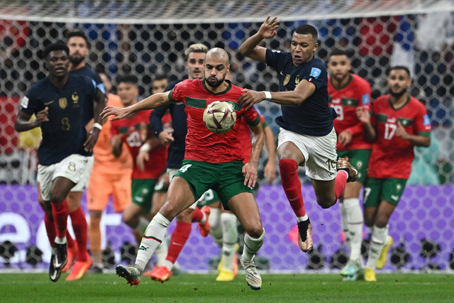 Pemain Timnas Prancis Kylian Mbappe berebut bola dengan pemain Timnas Maroko Sofyan Amrabat pada pertandingan semifinal Piala Dunia 2022 Qatar di Stadion Al Bayt, Al Khor, Qatar. Foto: Dylan Martinez/REUTERS