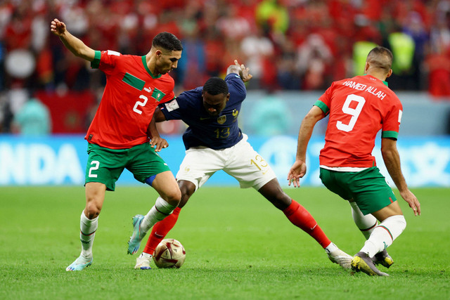 Pemain Timnas Prancis Youssouf Fofana berebut bola dengan pemain Timnas Maroko Achraf Hakimi pada pertandingan semifinal Piala Dunia 2022 Qatar di Stadion Al Bayt, Al Khor, Qatar. Foto: Carl Recine/REUTERS