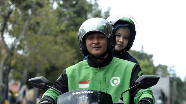 Hassanudin, driver GoRide bersama dengan penumpang. Foto: Gojek