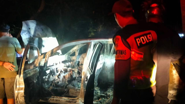 Polisi saat mengevakuasi mobil milik PNS di Kulon Progo yang terbakar. Foto: istimewa