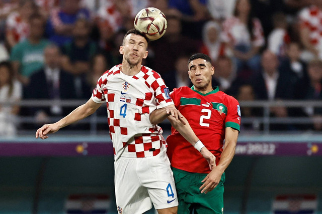Pemain Maroko Achraf Hakimi beraksi dengan pemain Kroasia Ivan Perisic pada perebutan tempat ke-3 Piala Dunia 2022 di Stadion Internasional Khalifa, Doha, Qatar, Sabtu (17/12/2022). Foto: Hamad I Mohammed/REUTERS
