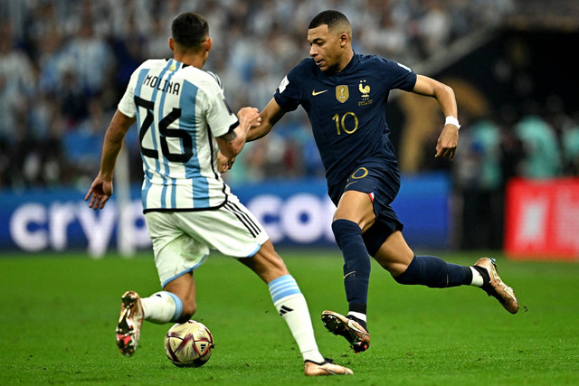 Pemain Prancis Kylian Mbappe beraksi bersama Argentina Nahuel Molina pada final Piala Dunia 2022, di Stadion Lusail, Lusail, Qatar, Minggu (18/12/2022). Foto: Dylan Martinez/REUTERS