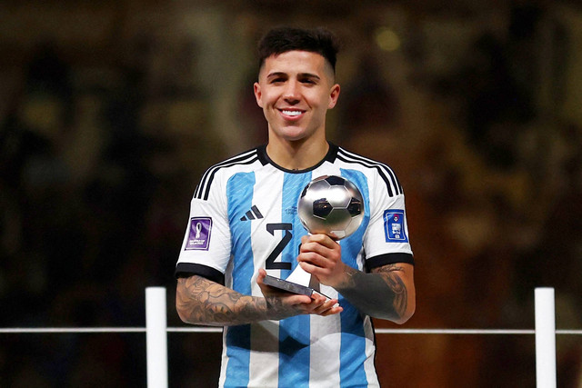 Pemain Argentina Enzo Fernandez berpose dengan piala penghargaan Pemain Muda Terbaik di Stadion Lusail, Lusail, Qatar, Minggu (18/12/2022). Foto: Carl Recine/REUTERS