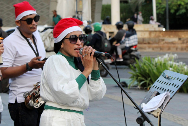 Para penampil menyanyikan lagu Natal di kawasan Bundaran Hotel Indonesia, Jakarta, Selasa (20/12/2022). Foto: Iqbal Firdaus/kumparan