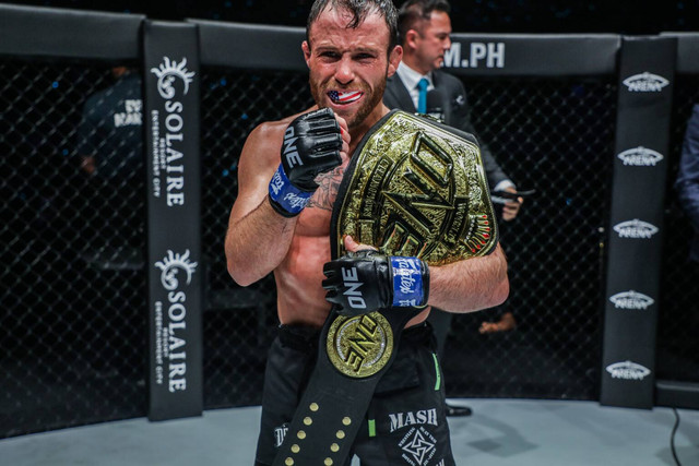 Jarred Brooks berpose dengan sabuk Juara Dunia ONE Strawweight setelah mengalahkan Joshua Pacio di ONE 164. Foto: ONE Championship