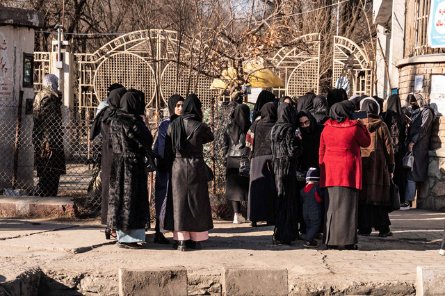 Mahasiswa perempuan Afghanistan dihentikan oleh petugas keamanan Taliban yang berdiri di samping sebuah universitas di Kabul, Afghanistan. Foto: Wakil Kohsar/AFP