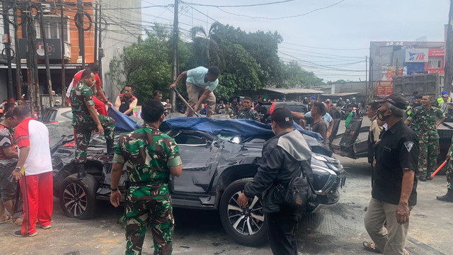 Petugas menderek mobil Pajero Sport yang tertimpa truk pasir di Jalan Alternatif Cibubur. Foto: Rinjani Meisa/kumparan