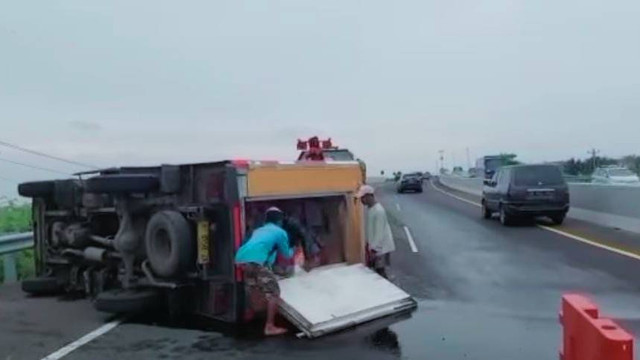 Truk tronton pengangkut minuman soft drink terbalik di ruas tol Pemalang-Pejagan tepatnya di KM 261 arah Jakarta, Minggu (25/12/2022) sore. (Foto Istimewa)