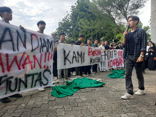 Aliansi mahasiswa Universitas Andalas melakukan demonstrasi dengan melepas almamater sebagai bentuk protes dan kekecewaan mereka terhadap kasus pelecehan seksual yang dilakukan oknum dosen di kampus tersebut, aksi ini dilakukan di depan pelataran gedung Rektorat Unand, Senin (26/12/2022). Foto: Ariyanti/Langkan