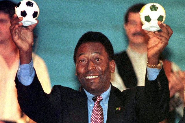 Edson Arantes Do Nacimiento, lebih dikenal sebagai "Pele", Menteri Olahraga Brasil, menunjukkan dua bola sepak keramik yang dibuat oleh anak-anak cacat, 15 Februari. Foto: Reuters
