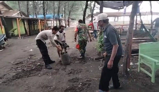 Warga bersama petugas dari TNI dan Polri bergotong-royong melakukan pembersihan usai kawasan wisata pantai di pesisir Kota Tegal, diterjang hujan deras disertai angin kencang dan ombak besar, Sabtu (31/12/2022) (Foto: Dok Grup RCT)