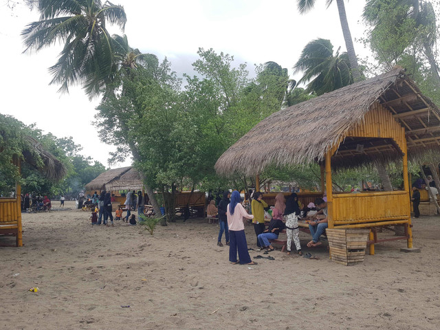 Keterangan foto:Wisatawan lokal tengah duduk beristirahat di lopo di Pintar Asia Beach. Foto:Mario WP Sina.