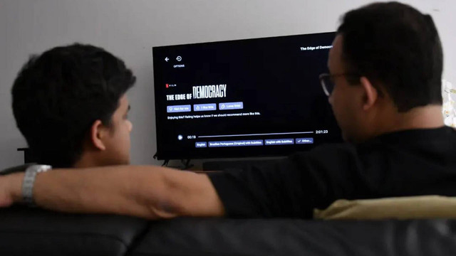 Anies Baswedan bersama Mikail menonton The Edge of Democracy (2019) di Netflix.  Foto: Instagram/@aniesbaswedan