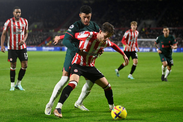 Pemain Liverpool Alex Oxlade-Chamberlai berebut bola dengan pemain Brentford  pada apertandingan lanjutan LIga Inggris di Stadion Komunitas Brentford, London, Inggris. Foto: Toby Melville/REUTERS
