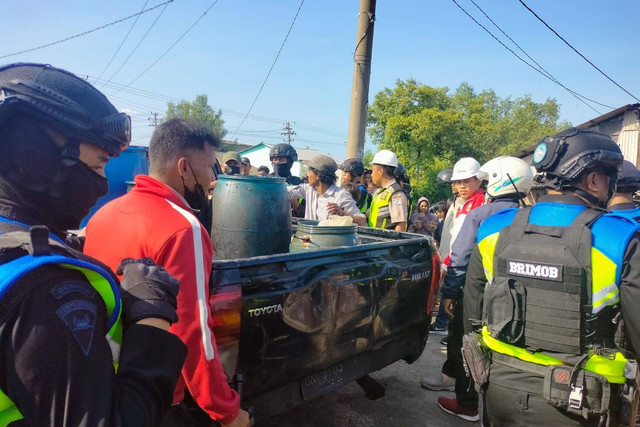 Polisi saat mengamankan barang bukti solar yang diambil warga dari pipa penyalur BBM jenis solar milik Pertamina di Medan. Foto: Dok. Istimewa