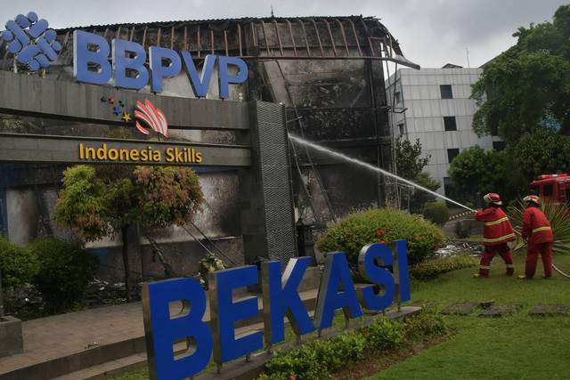 Petugas pemadam kebakaran melakukan pendinginan usai kebakaran Gedung Balai Besar Pelatihan Vokasi dan Produktivitas (BBPVP) Cevest di Bekasi, Jawa Barat, Rabu (4/1/2023). Foto: Fakhri Hermansyah/ANTARA FOTO