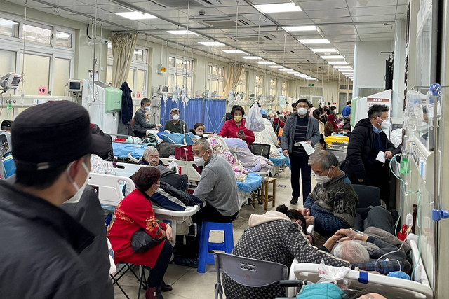 Pasien berbaring di tempat tidur dan tandu di lorong di unit gawat darurat rumah sakit, di tengah wabah COVID-19 di Shanghai, China, Rabu (4/1/2022). Foto: Staff/REUTERS