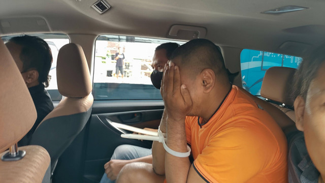 Salah satu tersangka dibawa polisi untuk menunjukkan di mana barang milik Jaksa KPK Ferdian Adi Nugroho. Foto: Arfiansyah Panji Purnandaru/kumparan