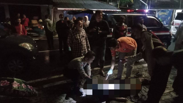 Petugas mengevakuasi jenazah seorang kakek yang meninggal di trotoar. Foto: istimewa