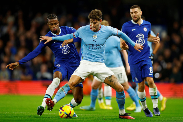 Pemain Chelsea Carney Chukwuemeka berebut bola dengan pemain Manchester City John Stones pada pertandingan lanjutan Liga Inggris di Stamford Bridge, London, Inggris. Foto: John Sibley/REUTERS
