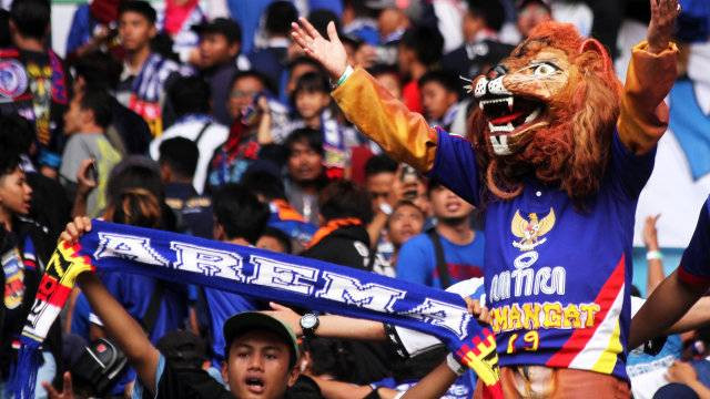 Suporter Arema FC merayakan kemenangan tim kesayangannya atas Bhayangkara FC di Stadion Patriot Candrabhaga. Foto: Risky Andrianto/Antara