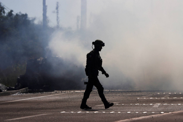 Seorang tentara berjalan di dekat kendaraan yang terbakar, setelah penahanan pemimpin geng narkoba Meksiko Ovidio Guzman, putra El Chapo, di Culiacan, Meksiko, Kamis (5/1/2023). Foto: Stringer/REUTERS