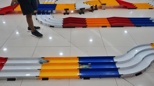 Adu cepat dua mobil di lintasan yang disediakan panitia dalam event balap tamiya yang digelar di lantai tiga mal Palembang Square, Minggu (8/1) Foto: abp/Urban Id