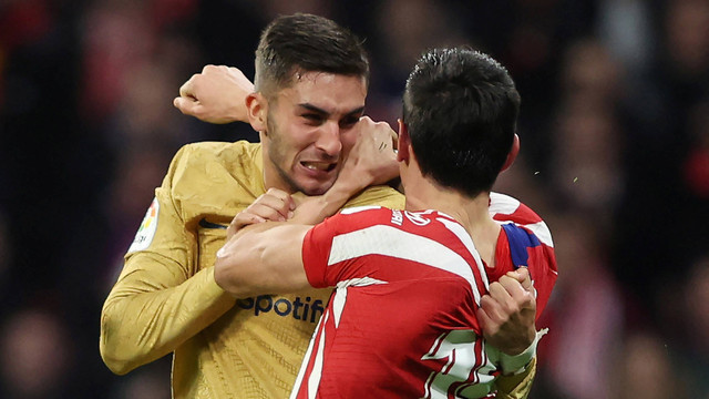Pemain Barcelona Ferran Torres (kiri) berkelahi dengan pemain Atletico Madrid Stefan Savic pada pertandingan di Metropolitano, Madrid, Spanyol. Foto: Thomas Coex/AFP